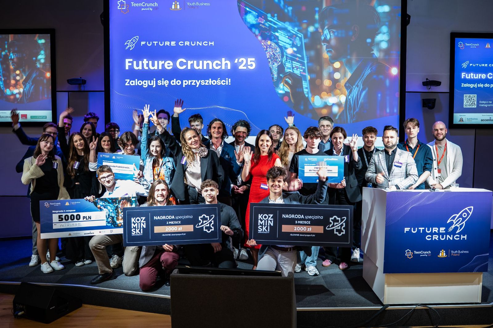 Group photo of finalists, jury and organisers on the FutureCrunch 2025 stage, holding prize boards including mTriage's first-place cheque and the Audience Award.