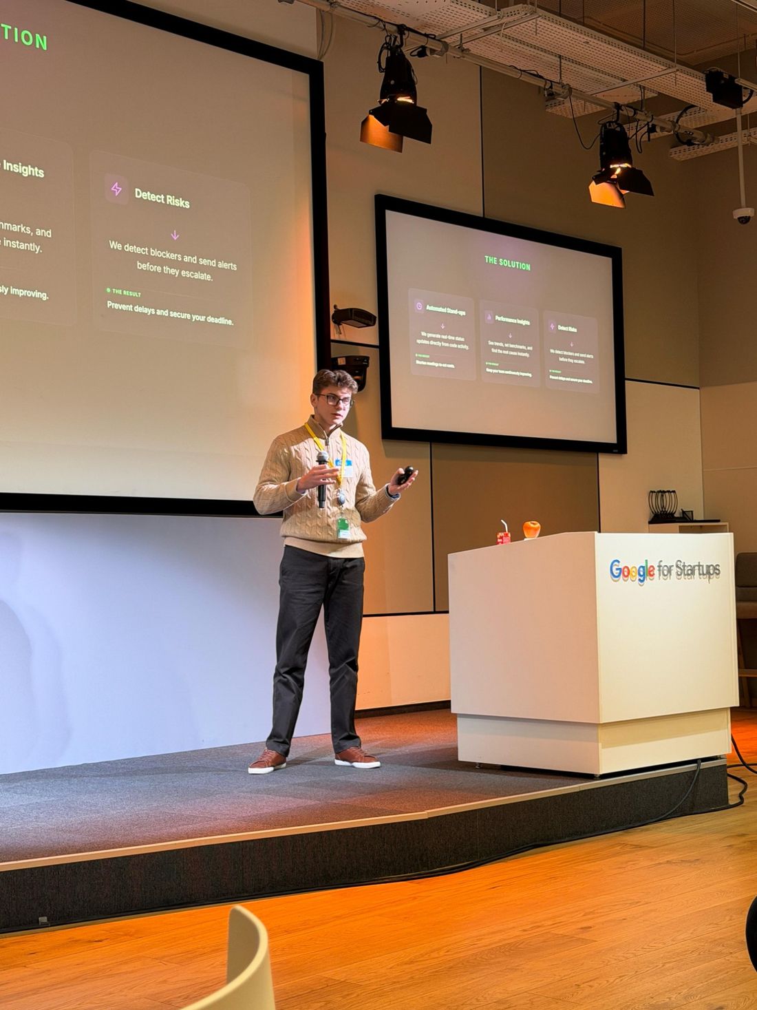 Mikita pitching on the Google for Startups stage in front of a slide titled The Solution.
